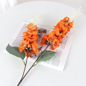 Artificial orange peacock orchid flowers for home wedding decor, two-pronged floral arrangement.