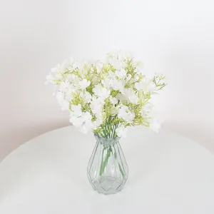 Elegante weiße künstliche Schleierkrautblumen in geometrischer Glasvase für Wohndeko