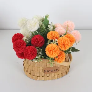 Fleurs artificielles de chrysanthème pompon dans un panier tissé pour la maison.