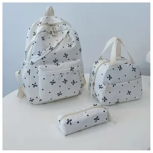 Bonito juego de mochila escolar con lunares y lazos con bolso y estuche de uso diario.