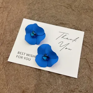 Detailaufnahme der französischen Vintage-Ohrringe mit blauer Blume und Kristallverzierung