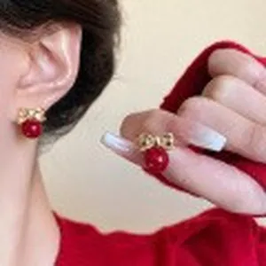 Detailed close-up showing vintage golden bowknot earrings with elegant red pearls for women