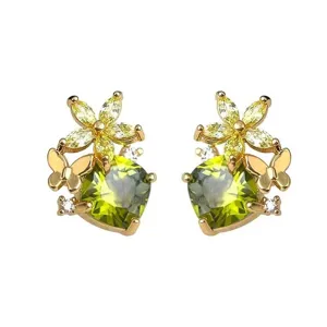 Close-up of green heart-shaped stud earrings with gold flower and butterfly design.