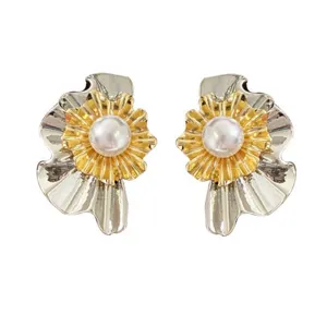 Detailansicht der gold-silbernen Ohrstecker in Blumenform mit einer zentralen Perle