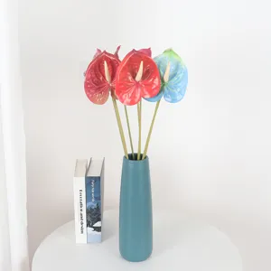 Artificial anthurium flowers bouquet in blue ceramic vase for elegant home interior decor