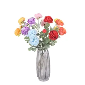 Veelkleurige 3-kops gevlokte kunstmatige Ranunculus bloemen in een grijze glazen vaas