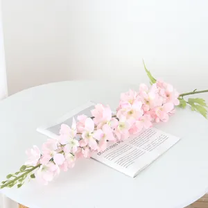 Gros plan détaillé d'une branche de fleurs de delphinium artificielles roses pour décoration.