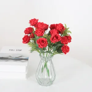 Bouquet di rose rosse artificiali con vaso in vetro per decorazione della casa e festa.
