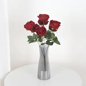Ramo de siete rosas artificiales de color rojo intenso en un jarrón de vidrio decor