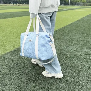 Light blue quilted yoga duffel bag detail, casual travel tote with white straps outdoors.