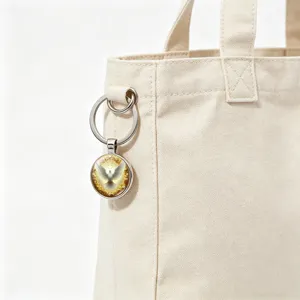 Close-up of a religious halo peace dove glass cabochon keychain on a canvas tote bag.