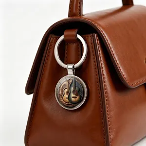 Detailaufnahme eines Vintage-Schlüsselanhängers mit Gitarrenmuster an einer braunen Ledertasche