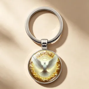 Macro view of a circular metal keychain pendant with a peace dove and golden halo
