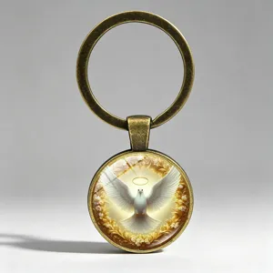 Close-up of a white dove with golden halo inside a vintage bronze glass keychain.