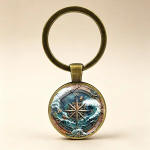 Detailed view of a vintage nautical compass keychain featuring waves and a sailing ship design