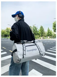 Large grey grid pattern travel duffel bag for camping and storage being carried
