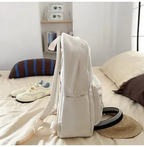 White casual backpack detail view, side pocket design, simple daily campus style school bag.
