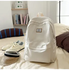 Minimalist off-white backpack detail view showing front woven patch and clean everyday design.