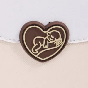 Vue détail de sac à langer avec joli logo cœur de bébé endormi sur un tissu très résistant.
