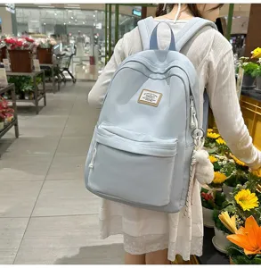Casual light blue backpack for women, large capacity daily school bag with cute fluffy charm.