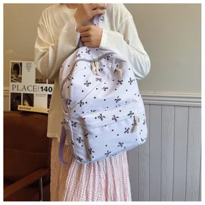 Mochila informal morada para mujer y estudiantes con lindo motivo de lazos y lunares.