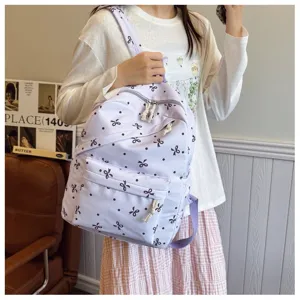 Bonita mochila morada con estampado de lazos, mochila escolar casual para mujeres y uso diario.