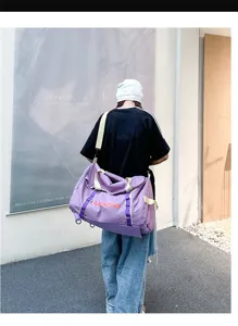 Large purple checkered travel storage bag carried by a model in a lifestyle outdoor setting