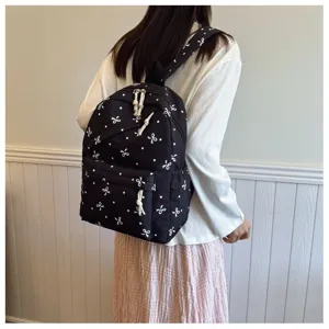 Mochila negra elegante para mujer con estampado de lazos blancos, bolso casual de gran capacidad.