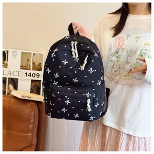 Mochila negra casual con estampado de lunares y lazos blancos, gran capacidad para viajes.