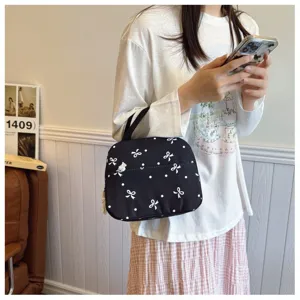 Primer plano detallado del bolso negro con bonito diseño estampado de lazos y lunares.