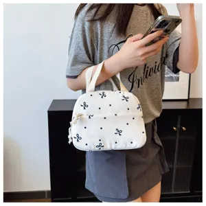 Bolso de mano compacto de lona blanca con bonitos lazos azules y estampados de lunares.