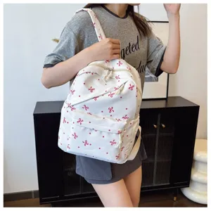 Mochila blanca de lona bonita con estampado de lazo rojo para mujer uso diario