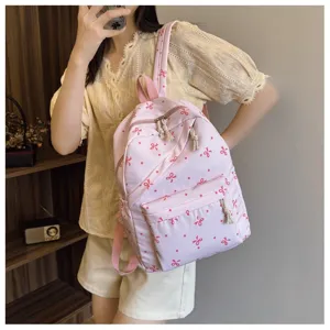 Vista de cerca de la mochila rosa con bonito diseño de lazo, estilo casual y uso diario práctico.