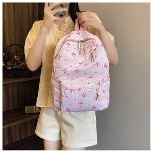 Vista detallada de una bonita mochila rosa con lazos y lunares para uso diario y casual.