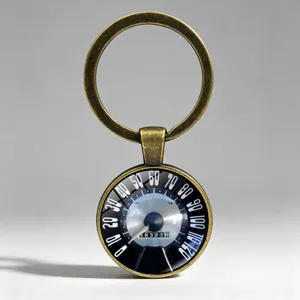 Close-up of retro car speedometer keychain with vintage bronze finish and glass dome