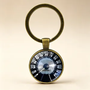 Detail view of vintage speedometer car keychain in bronze finish with glass cabochon