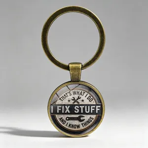 Primer plano de un llavero de bronce vintage con el texto 'I FIX STUFF' y herramientas