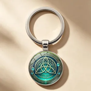 Dettaglio macro di un portachiavi a nodo celtico con cabochon in vetro verde e argento