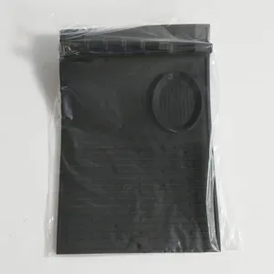 Detailansicht einer schwarzen Silikon-Grillmatte in einer klaren Schutzverpackung aus Plastik.