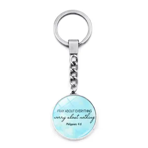 Detailopname van een zilveren metalen sleutelhanger met inspirerende bijbelse tekst