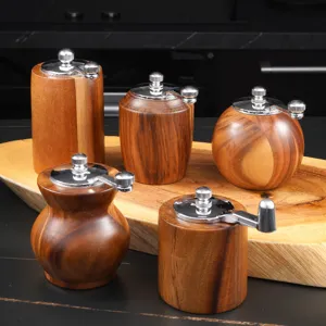 Acacia wood manual pepper grinder detail view, showcasing natural grain texture and metal crank.