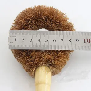 Diameter van de kokosvezel afwasborstelkop gemeten met een stalen liniaal voor maat.