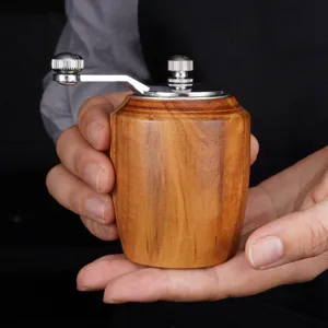 Manual wooden pepper grinder and spice mill featuring metal handle for kitchen cooking use.