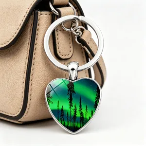 Nahaufnahme eines herzförmigen Schlüsselanhängers mit Polarlichter-Design an Ledertasche