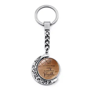 Detailed view of rotating moon keychain with inspirational Faith quote engraving