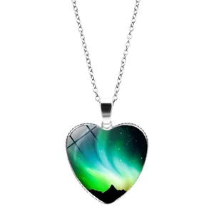 Close-up of a heart-shaped pendant featuring a vibrant aurora borealis sky design.