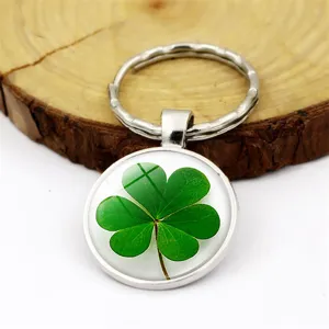 Détail macro d'un porte-clés trèfle à quatre feuilles avec cabochon en verre transparent