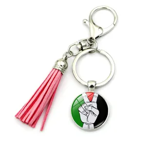 Détail d'un porte-clés drapeau palestinien avec pompon rose et fermoir mousqueton robuste
