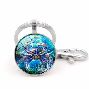Detail view of a Cancer zodiac glass cabochon keychain with a silver lobster clasp