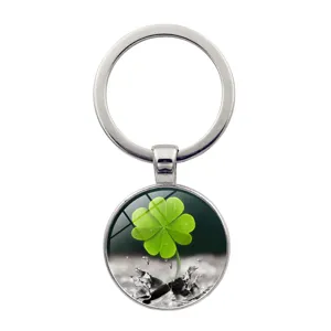 Detailed macro view of a lucky four-leaf clover keychain with glass cabochon pendant.